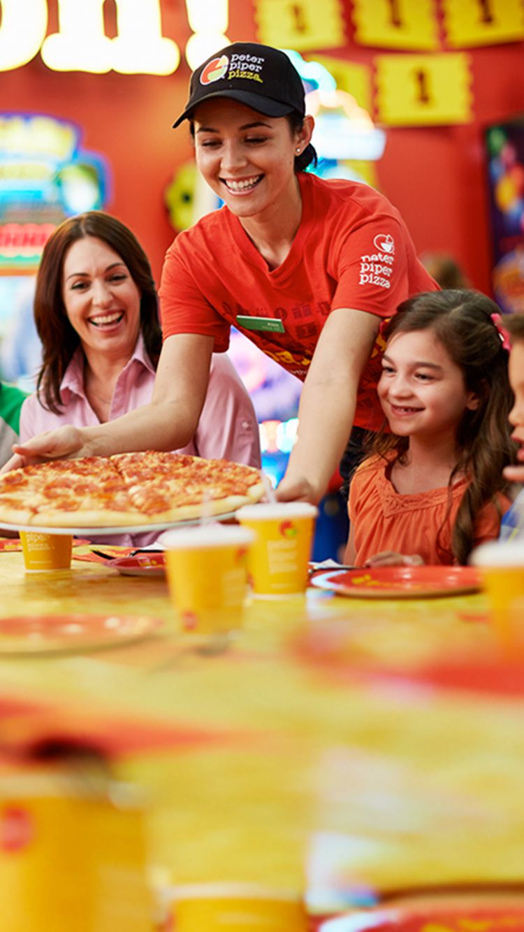 Peter Piper Pizza's Banner of Happy Customers being served a delicious pepperoni pizza by the warm and welcoming Peter Piper Pizza waitress