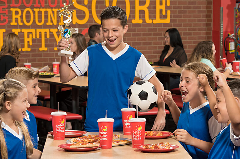 Niños felices disfrutando de su comida en equipo en Peter Piper Pizza